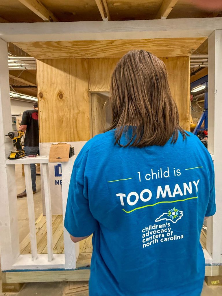 A representative from AWAKE Children's Advocacy Center tours the lab where construction management students are building playhouses they designed with support from and materials donated by America's Home Place.
