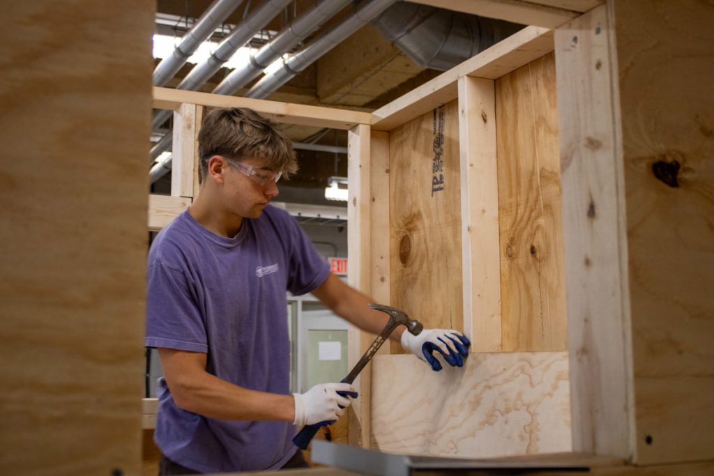 A WCU construction management student works on a playhouse for AWAKE Children's Advocacy Center. Materials were donated by America's Home Place.