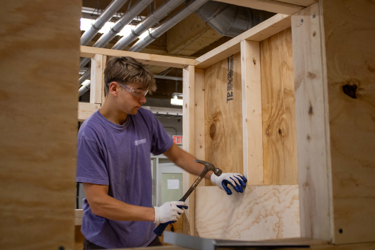 A WCU construction management student works on a playhouse for AWAKE Children's Advocacy Center. Materials were donated by America's Home Place.