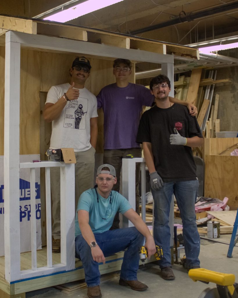 A team of WCU construction management students stands with the playhouse they are building with support from America's Home Place to support AWAKE Children's Advocacy Center.