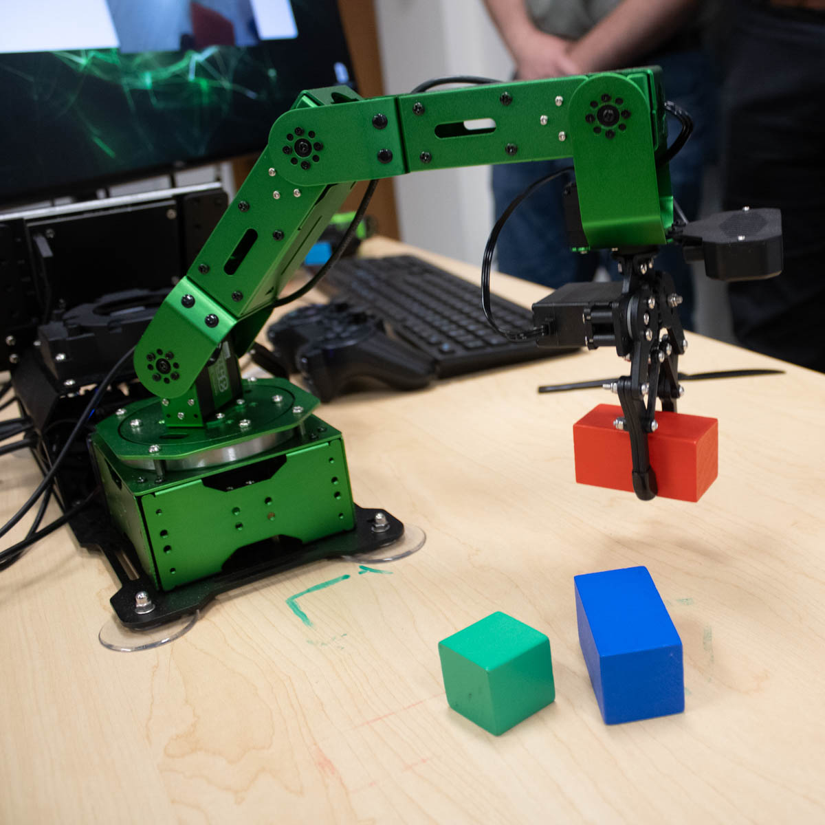 Green Hulk robot picks up red block