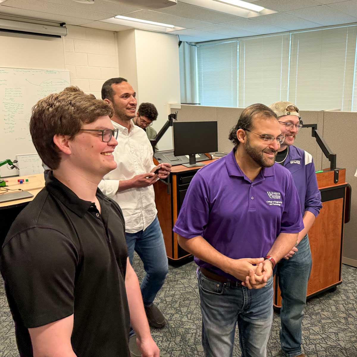 Faculty and students smile during demonstrations of the robots in the Spring 20256 ENGR 493’s AI + Robotics course