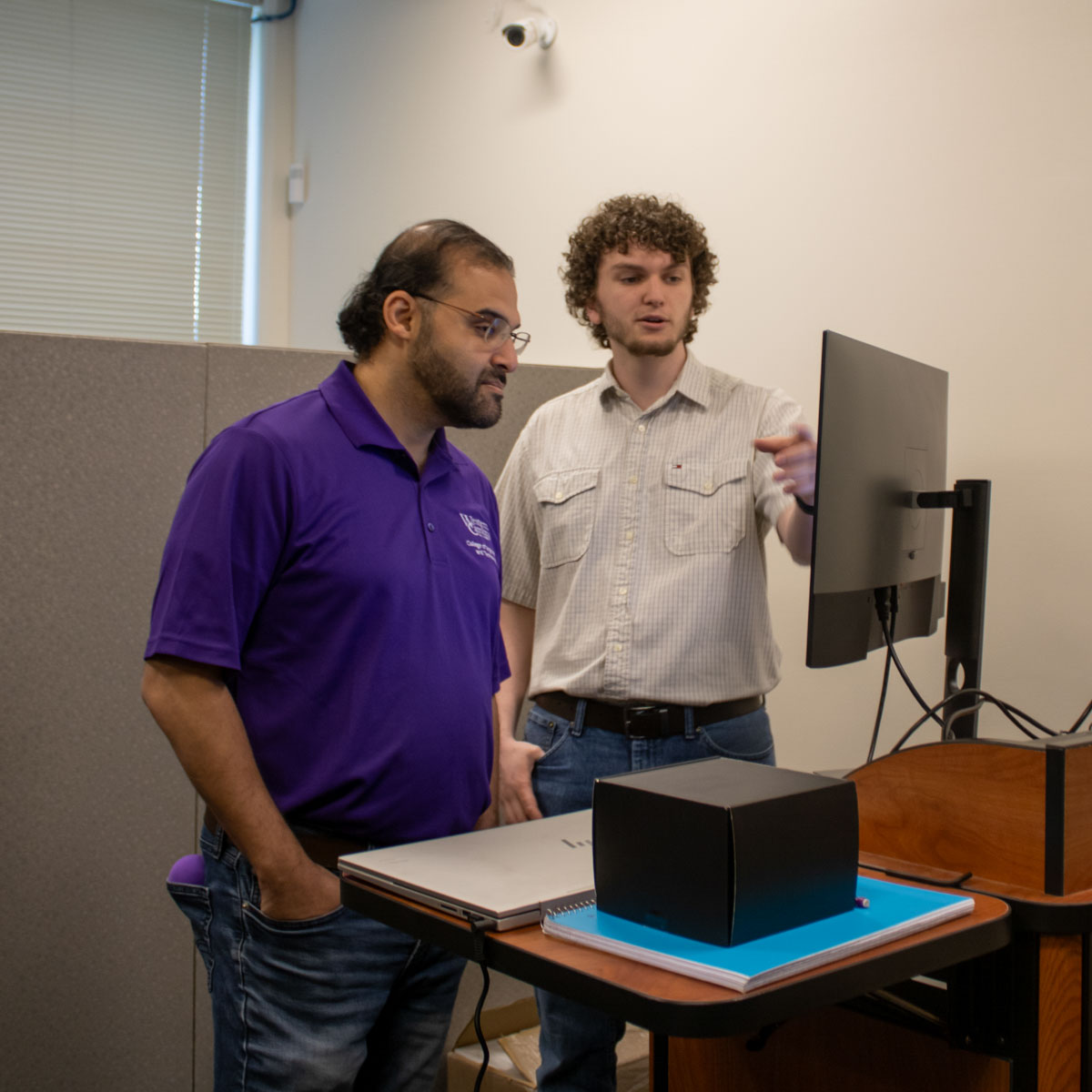 A student and Dr. Abdallah look at a computer monitor