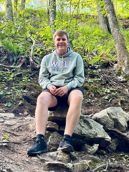 Connor Thompson sitting on a rock