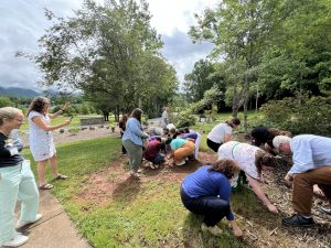 Educators are outside picking materials up from the ground as they participate in an engaging science lesson